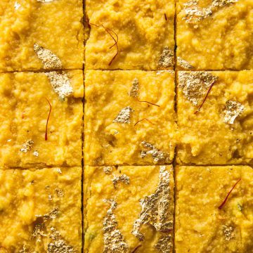 Microwave Mango Barfi topped with gold leaf and cut into squares.