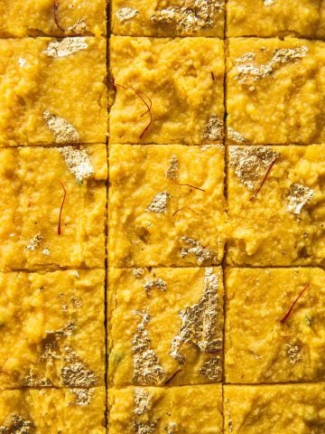 Microwave Mango Barfi topped with gold leaf and cut into squares.