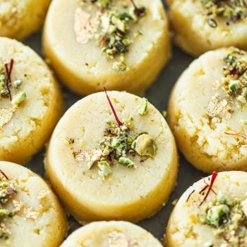 Malai Peda (Indian Milk Fudge) garnished with pistachio, saffron and gold leaf.