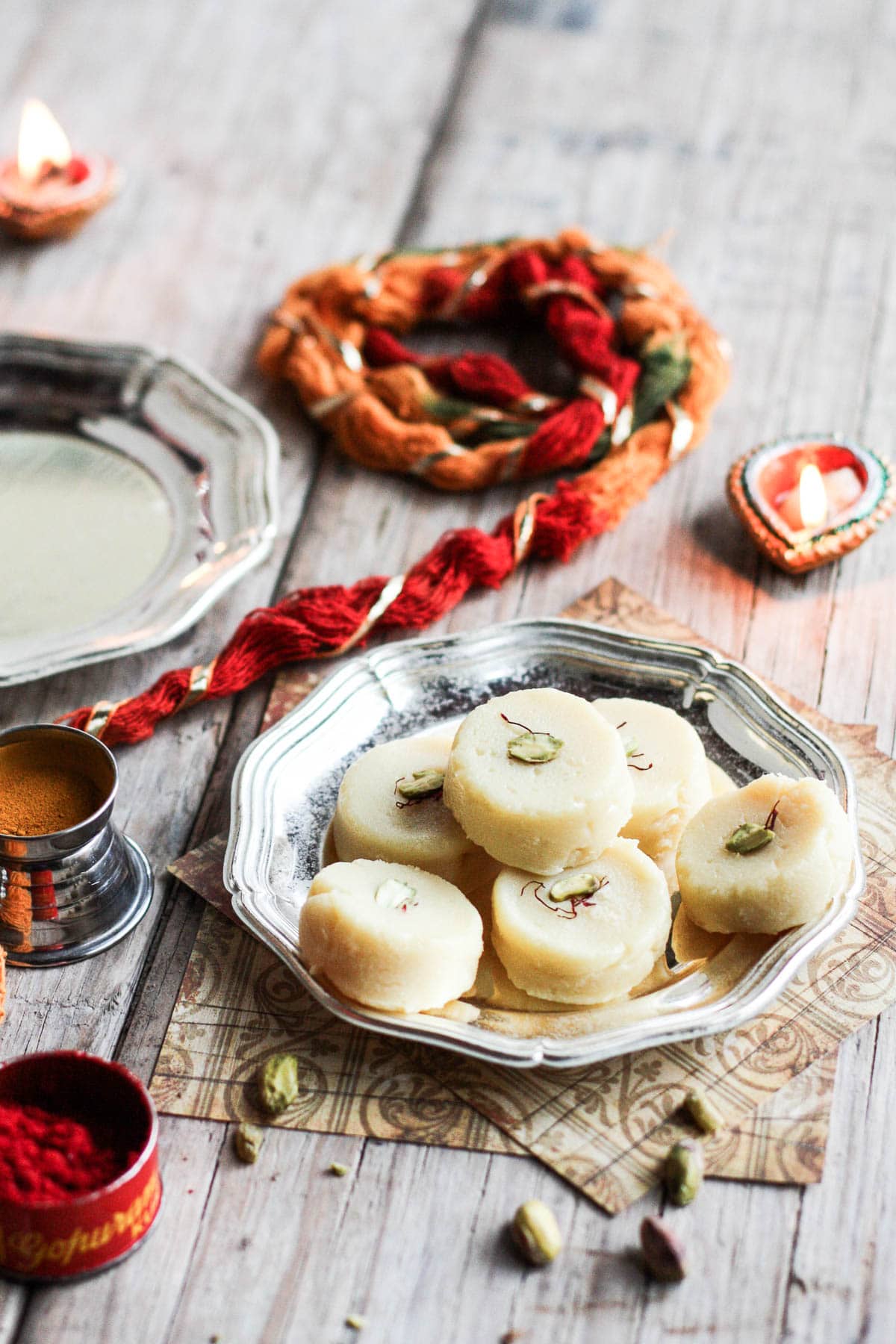 Malai Peda served in a traditional Diwali Thali with kumkum, auspicious thread and diyas.