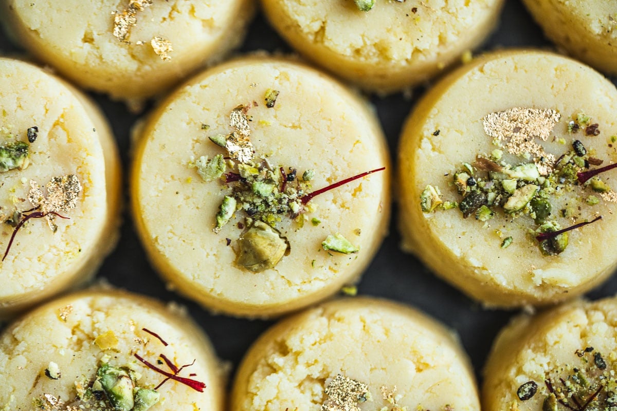 Malai Pedas garnished with pistachio, cardamom, saffron and gold leaf.