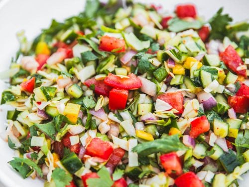 Kachumber Salad in a bowl with a spoon.