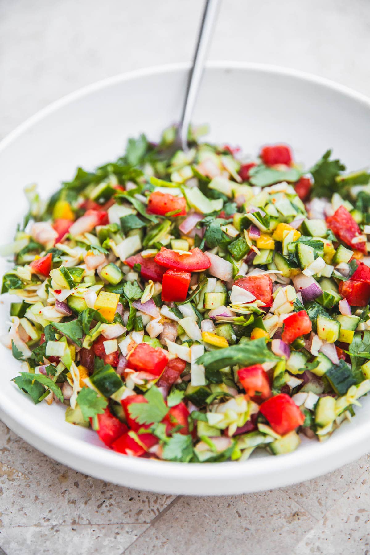 Kachumber Salad in a bowl with a spoon.