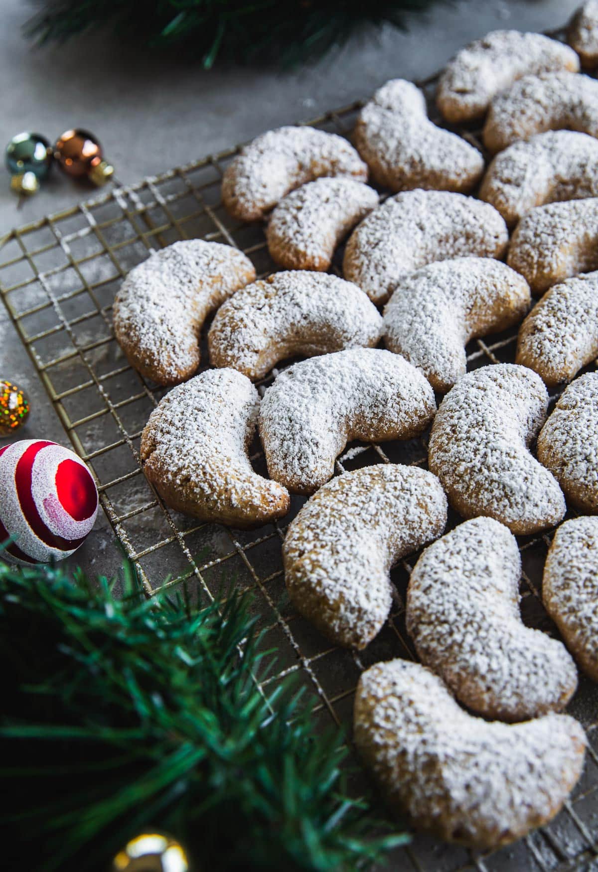 Kourabiedes - crescent shaped Greek Christmas cookies dusted with icing sugar on a wire rack.