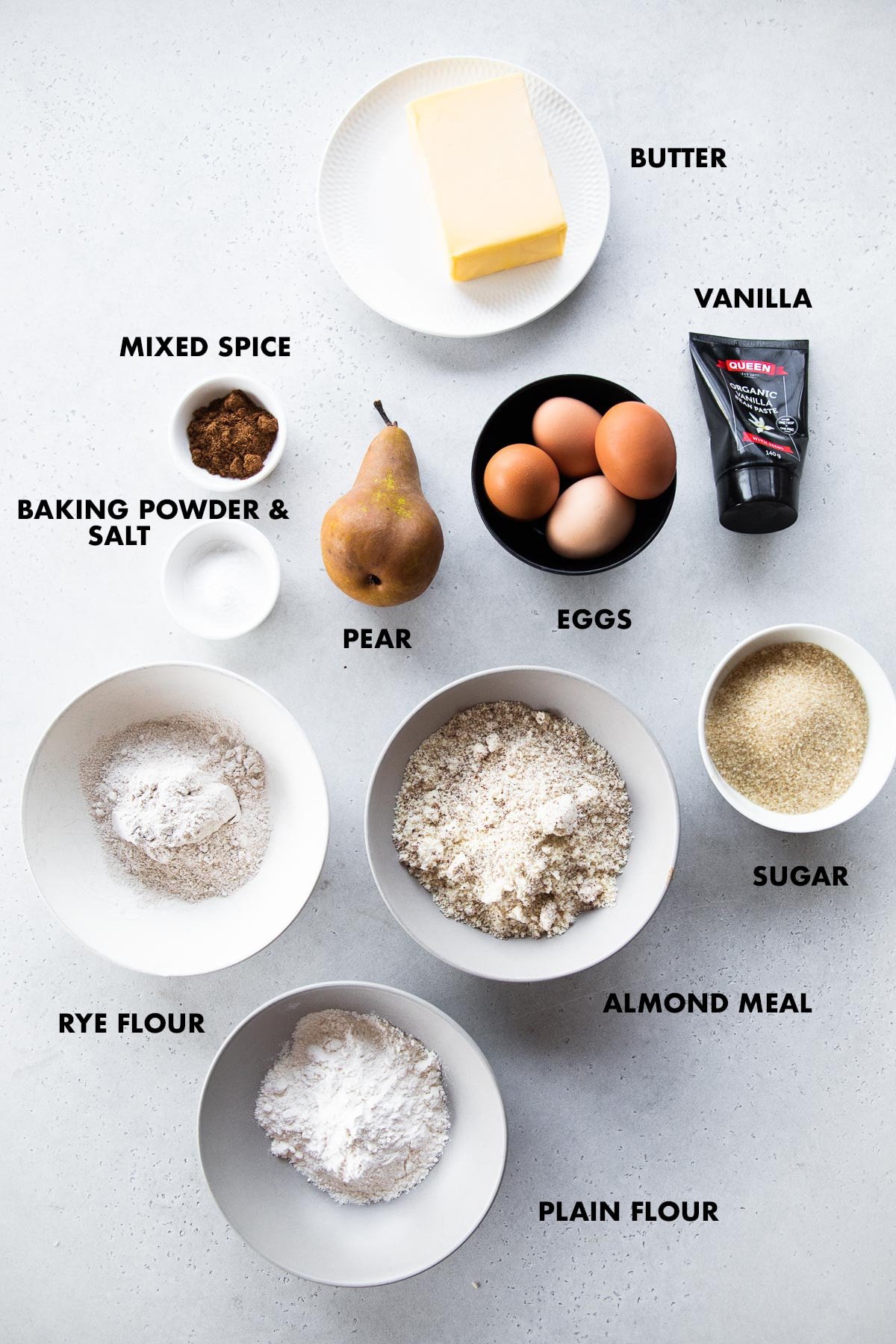 Spiced Pear Cake ingredients measured and labeled - butter, eggs, sugar, vanilla, rye flour, almond meal, plain flour, salt, mixed spice, baking powder and pear.