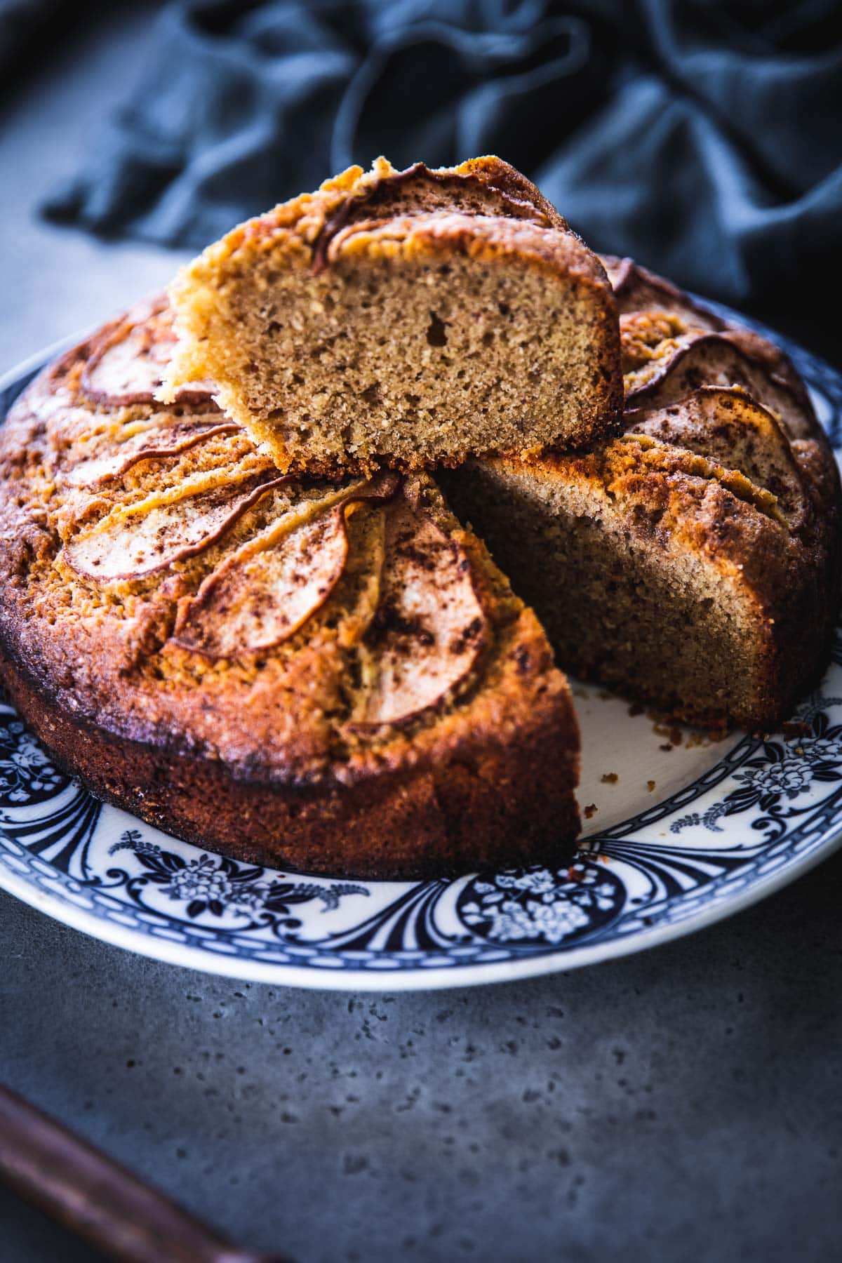Spiced Pear Cake with a slice cut and resting on top of the whole cake.