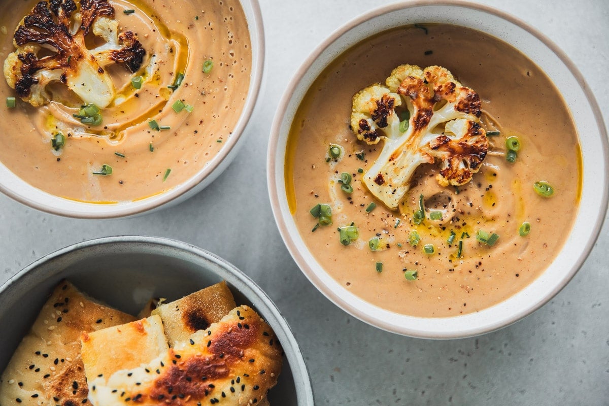 Garnish Roasted Cauliflower Soup with roasted cauliflower floret, butter and chives.