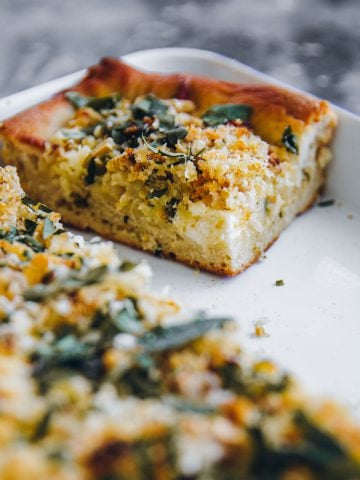 A square slice of Roasted Cauliflower Grandma Pie in a white tray.