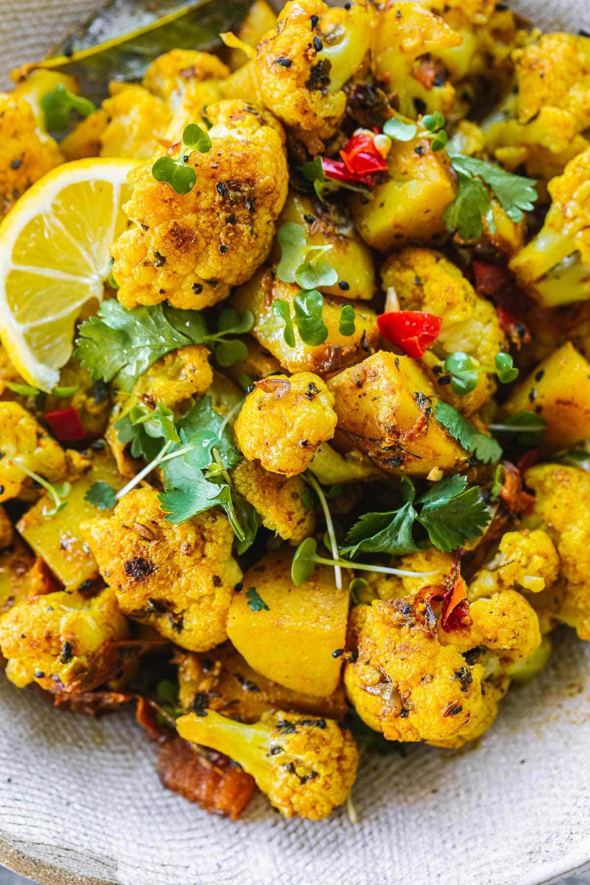 Close up of Aloo Gobi - a dry Indian curry made of potato, cauliflower and spices.