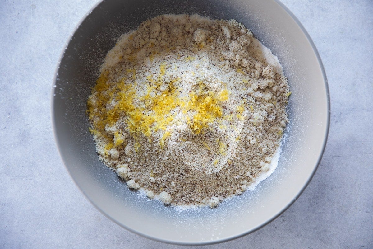 Add sifted flour, almond meal, baking powder and lemon zest to a bowl.