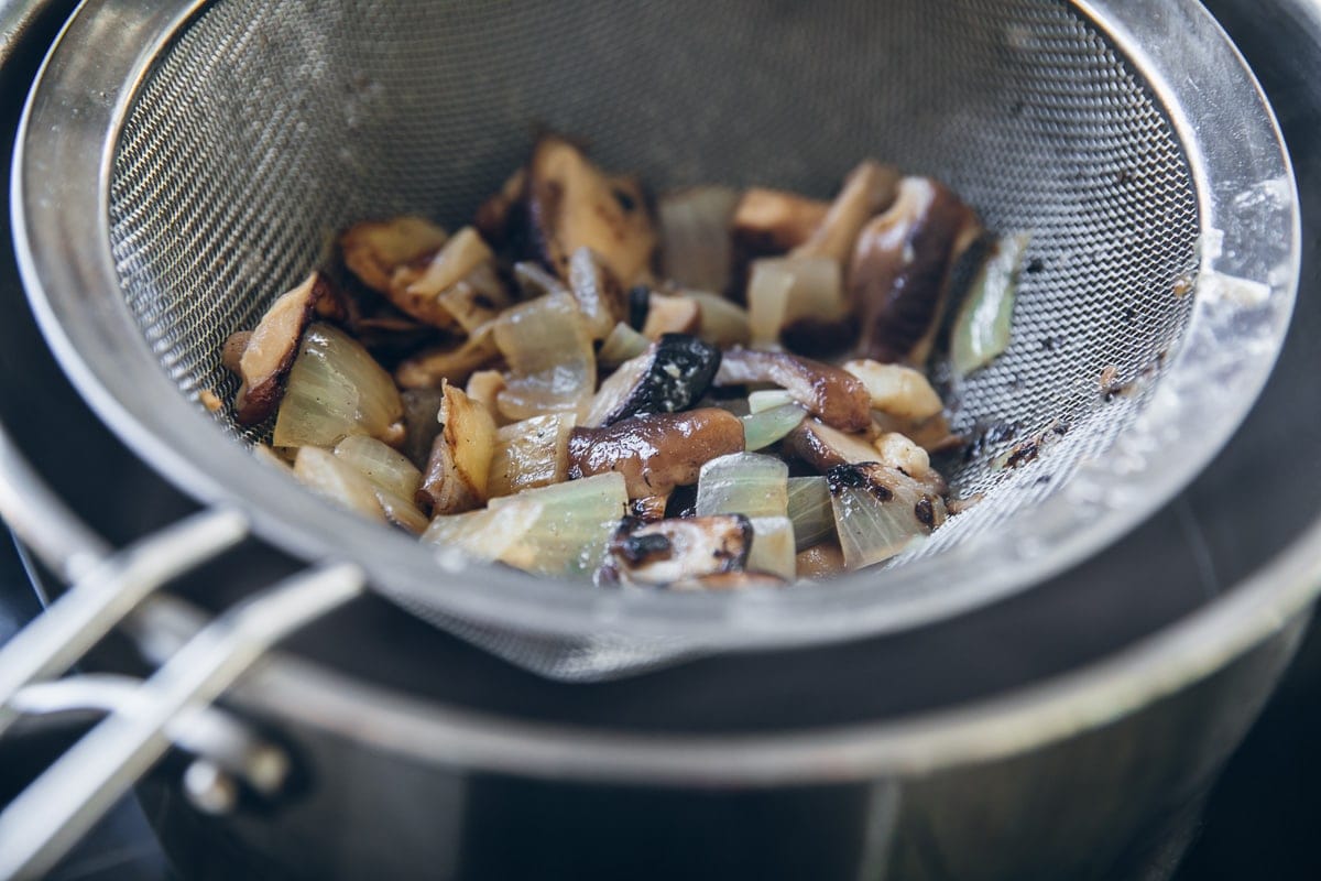 Strain the Vegan Ramen Broth and return liquid to the pan on low heat - Cook Republic