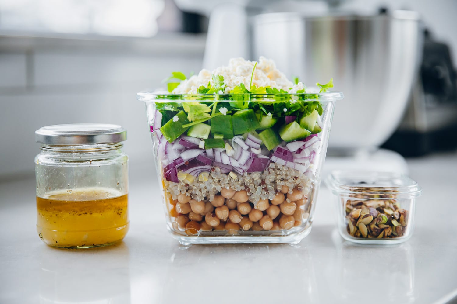 Préparation des repas Salade Jennifer Aniston dans trois récipients en verre séparés et conservation au réfrigérateur pour plus tard