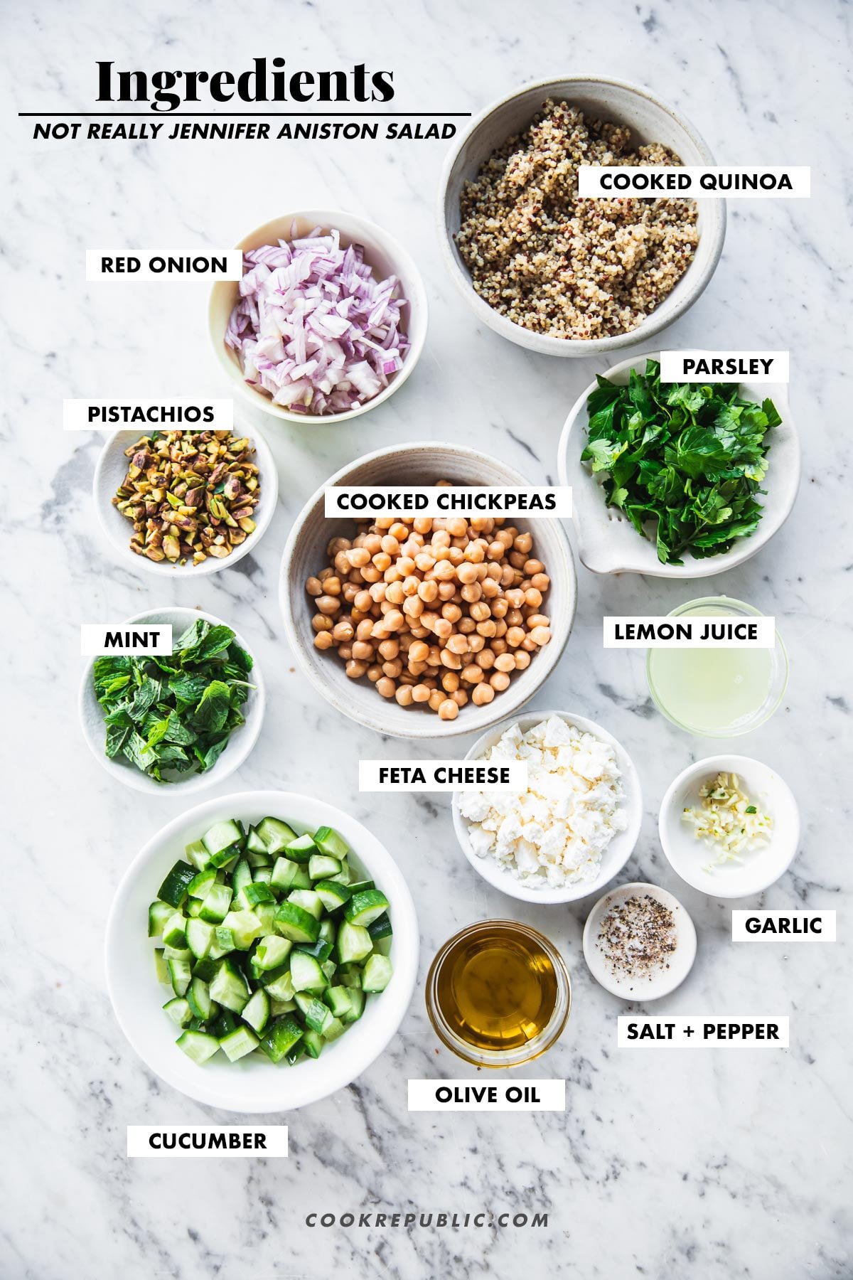 Jennifer Aniston Salad ingredients measured in bowls quinoa, chickpeas, onion, cucumber, pistachios, feta cheese, parsley, mint, lemon juice, garlic, olive oil, salt and pepper.