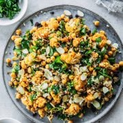 Roasted Cauliflower Salad With Chickpeas And Quinoa served in a salad platter with extra parsley and almond flakes on the side.