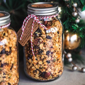 Homemade Granola stored in glass jars with twine and a handwritten label for gifting at Christmas.