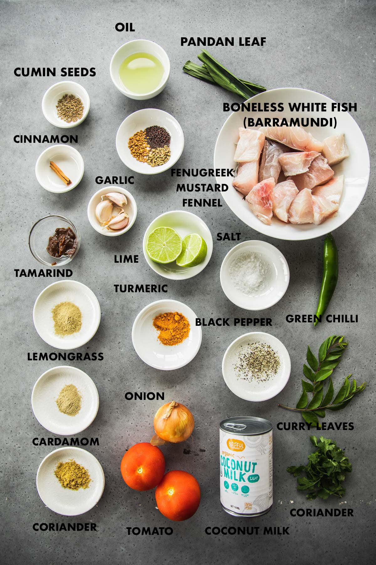 Sri Lankan Fish Curry ingredients measured and labeled - Barramundi fish, onion, tomato, garlic, curry leaves, chilli, coconut milk, tamarind, pandan, black pepper, cardamom, cumin, coriander, fennel, mustard, fenugreek, turmeric, cinnamon, pandan, lemongrass and lime.