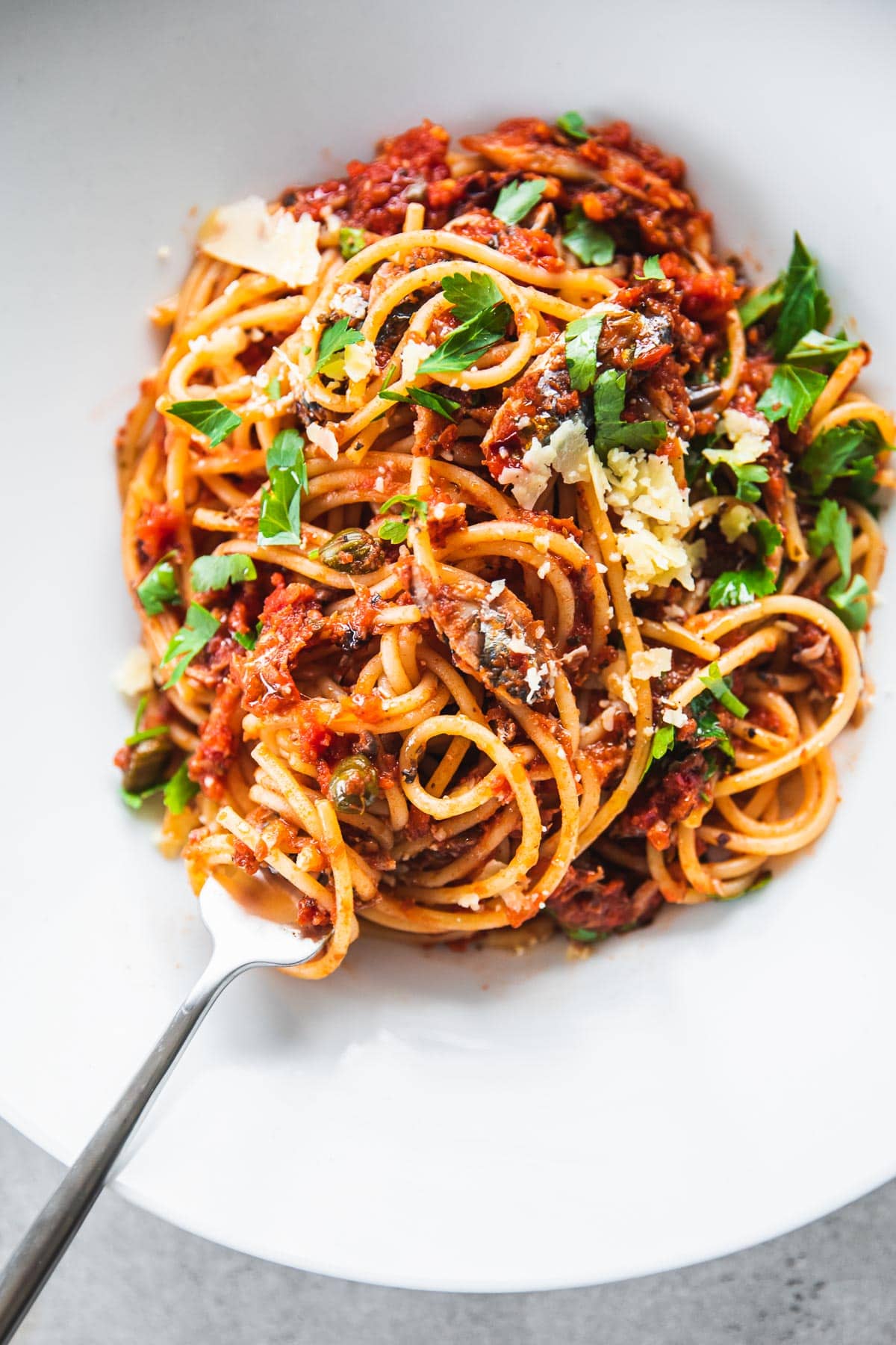 Sardine pasta in a white bowl with a fork.