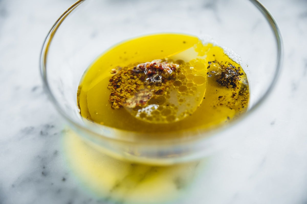 Green Avocado Salad Dressing in a bowl - lime juice, olive oil, wholegrain mustard, maple syrup, salt and pepper.