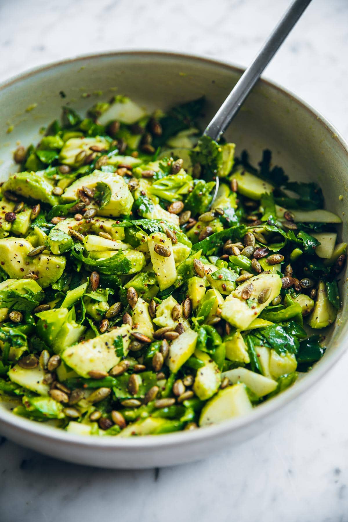 Green Avocado Salad prepped and tossed in a bowl.