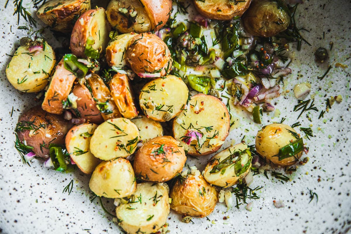 Roasted Dill Potato Salad coates in a zesty dressing in a bowl.