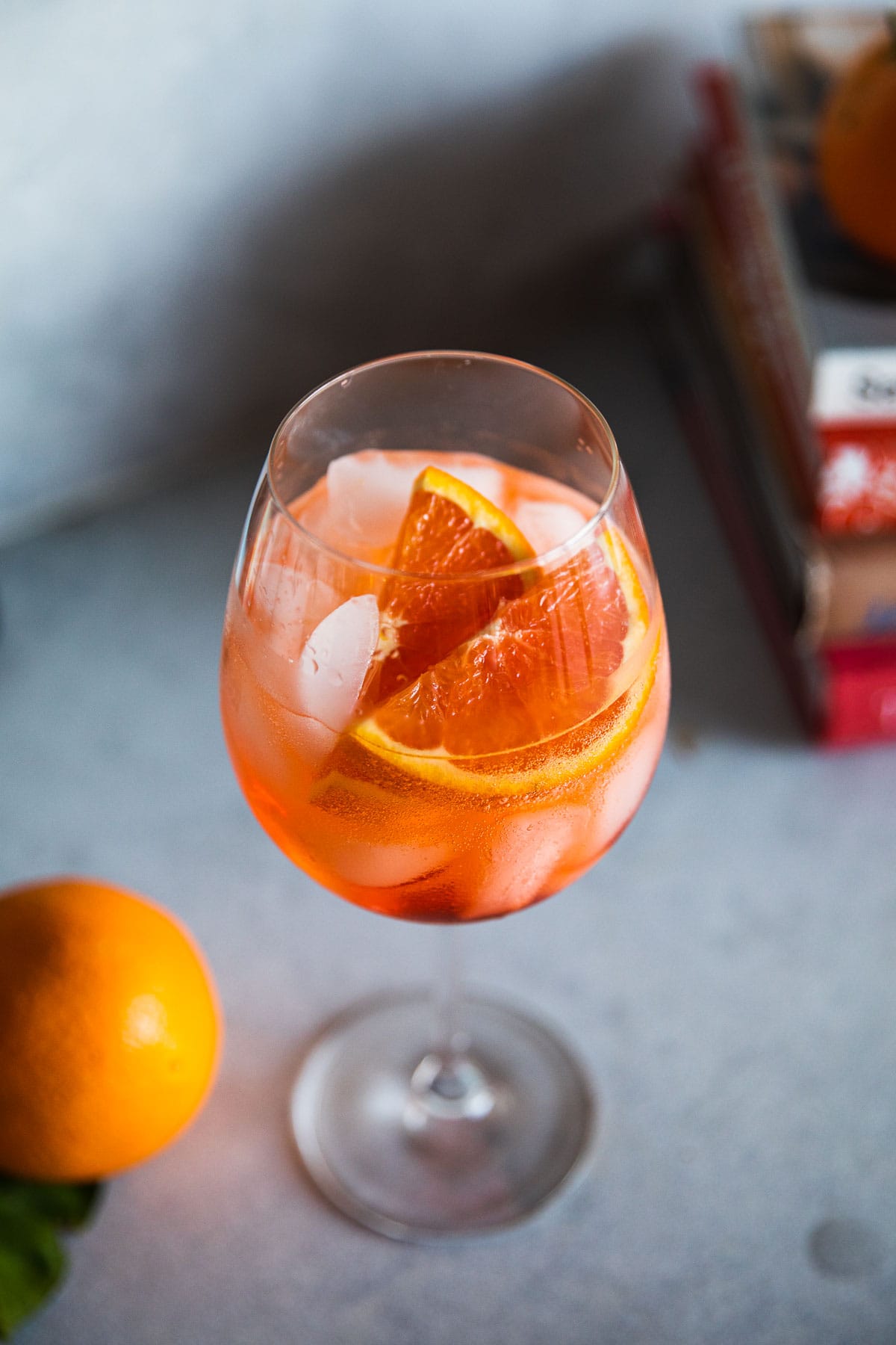 Aperol Spritz in a wine glass on ice and garnished with orange slices.
