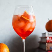 Aperol Spritz in a stemmed wine glass on the kitchen counter.