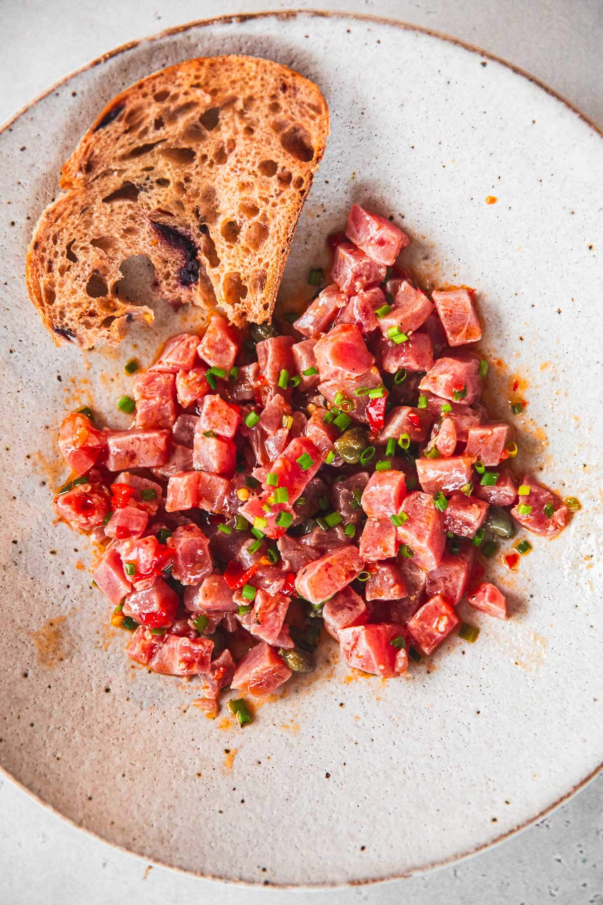 Italian Tuna Tartare served with toasted olive sourdough in a bowl.