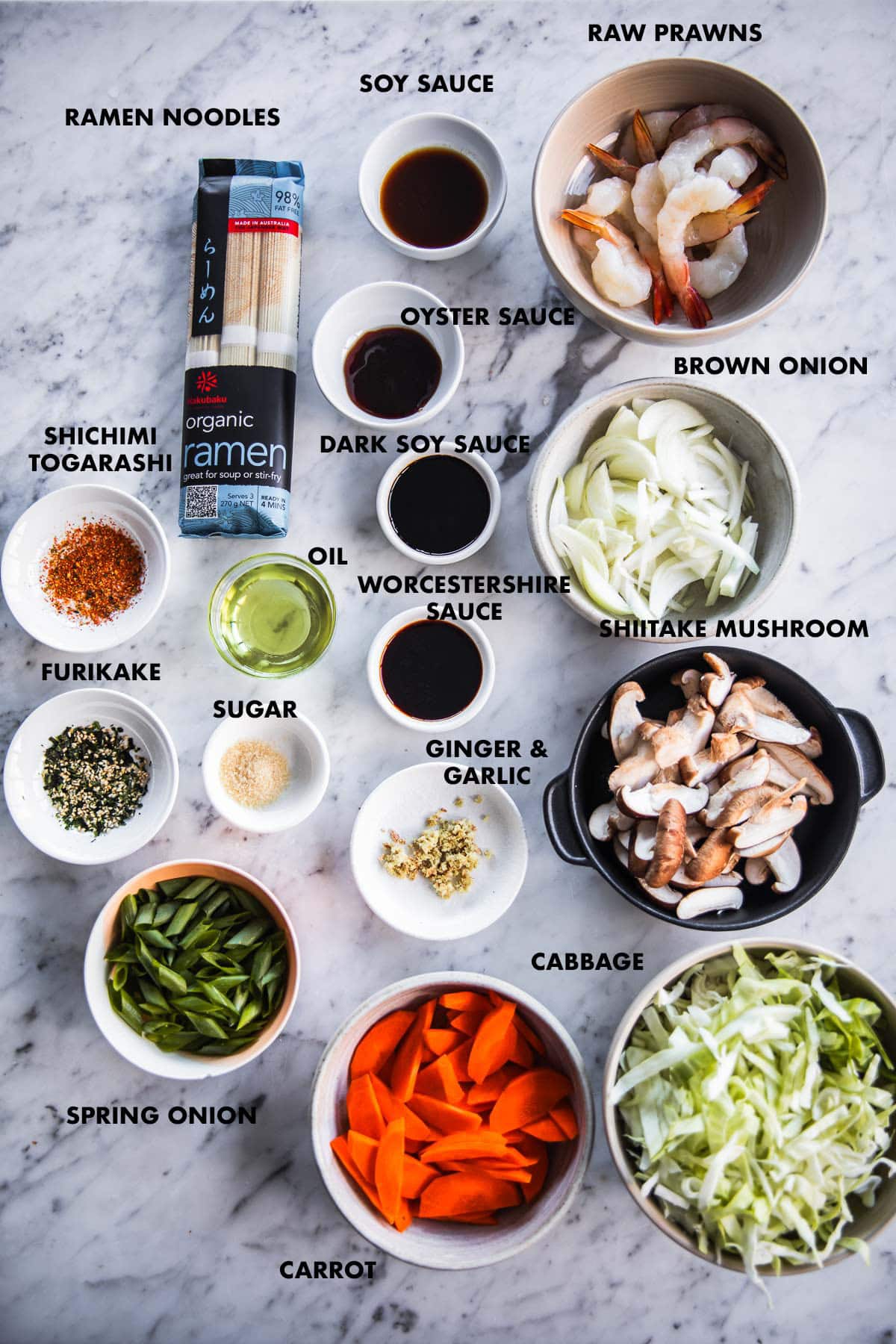 Yakisoba ingredients measured and labeled - Raw prawn meat, ramen noodles, cabbage, onion, carrot, shiitake mushroom, spring onion, ginger, garlic, sugar, soy sauce, dark soy sauce, oyster sauce, worcestershire sauce, shichimi togarashi and furikake.
