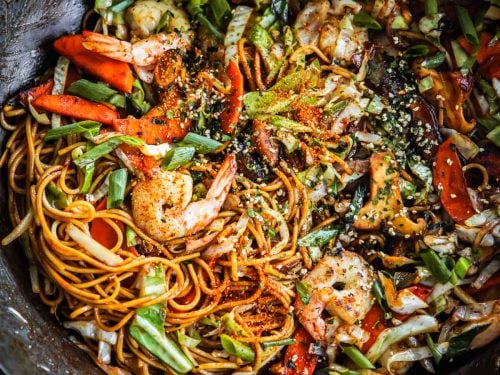 Prawn Yakisoba stir-fried in a wok with a tea towel around the wok handle.