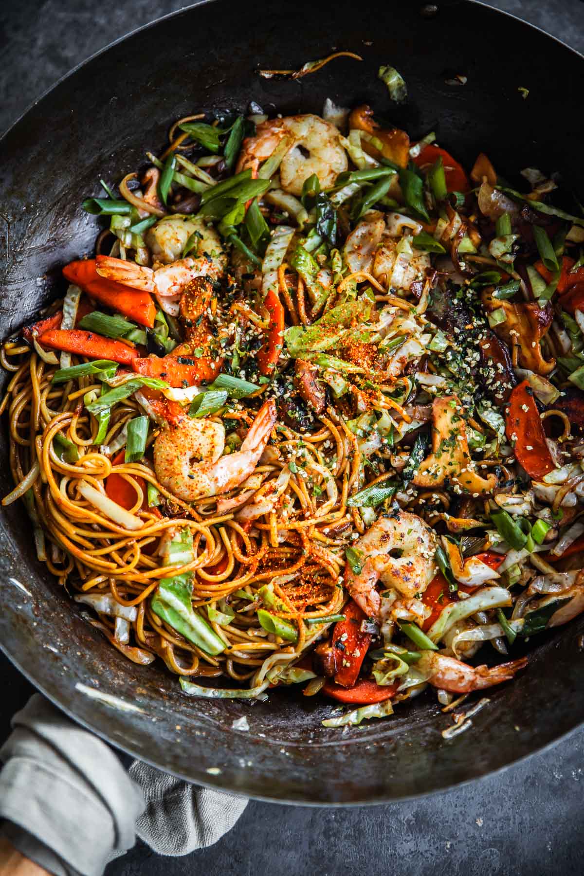 Prawn Yakisoba stir-fried in a wok with a tea towel around the wok handle.