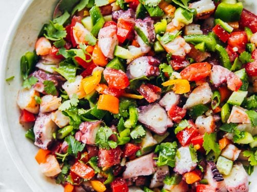 Pipiranna - Spanish Seafood Summer Salad in a bowl with a linen napkin on the side.