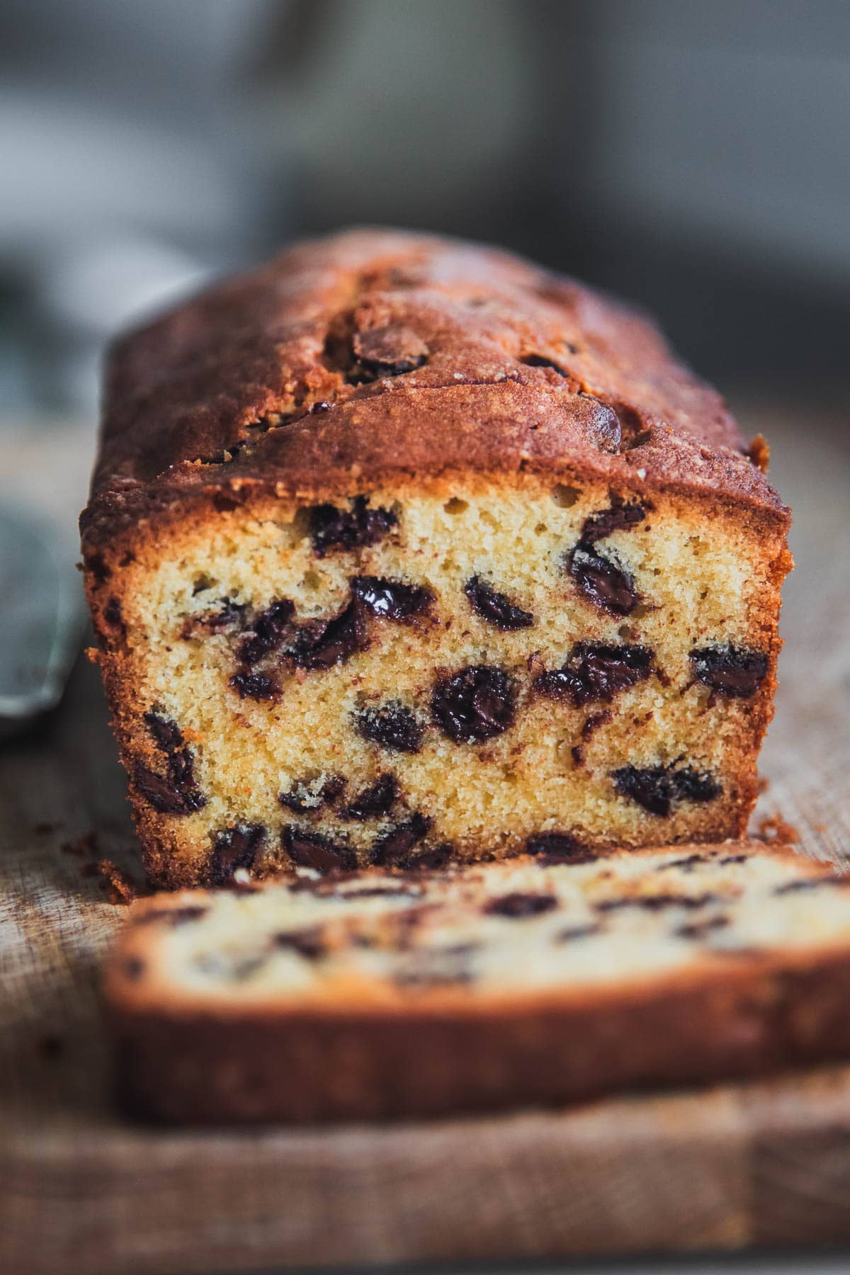 Chocolate Chip Pound Cake Loaf with a slice cut on a chopping board.