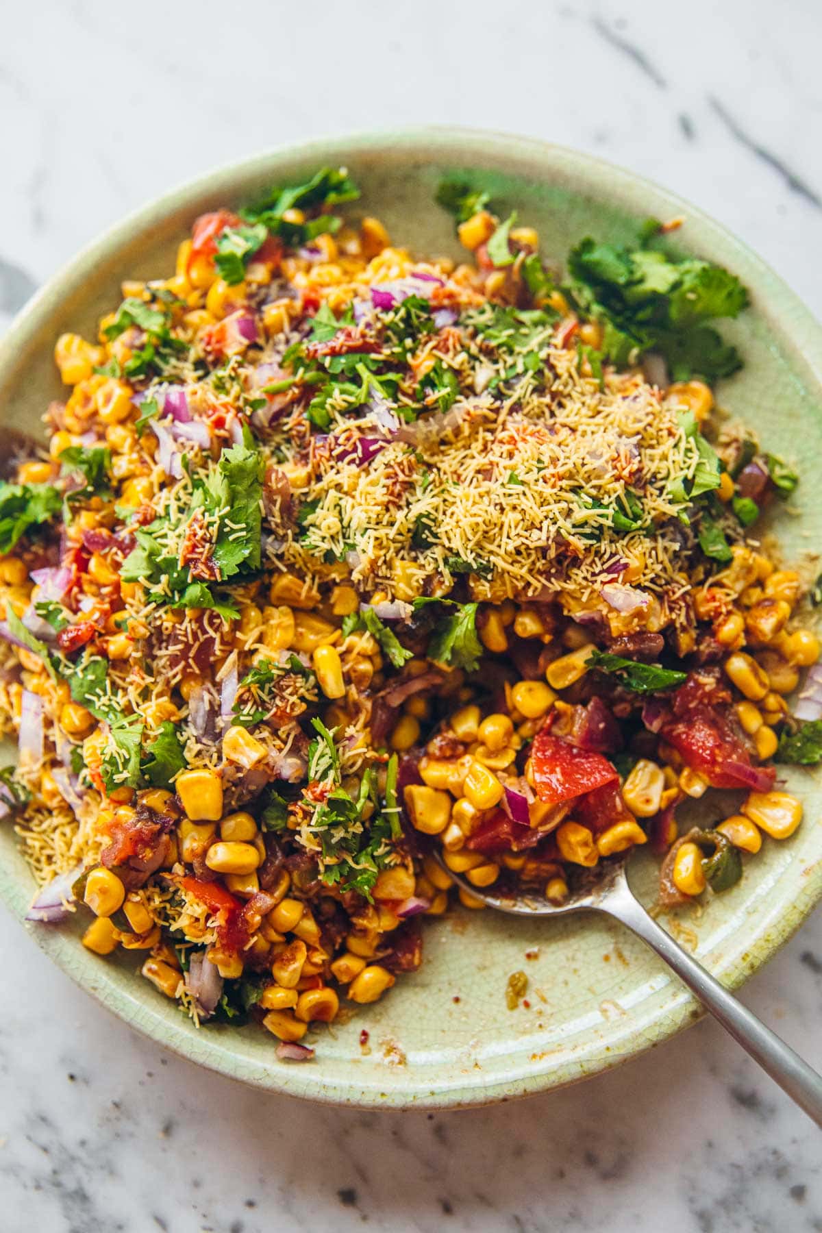 Corn Chaat topped with Nylon Sev, Coriander and Onion.