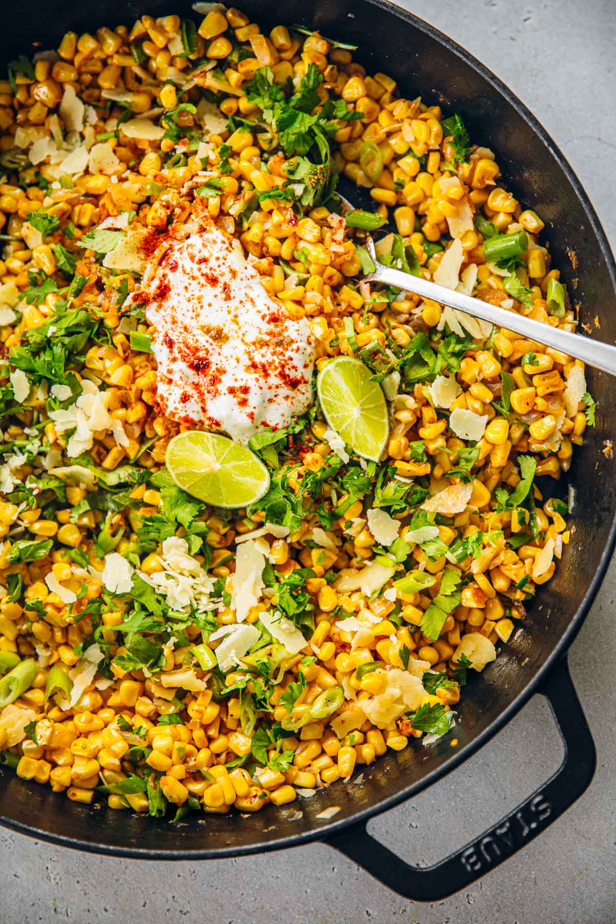Mexican Corn Salad served with yoghurt, cheese and lime wedges.