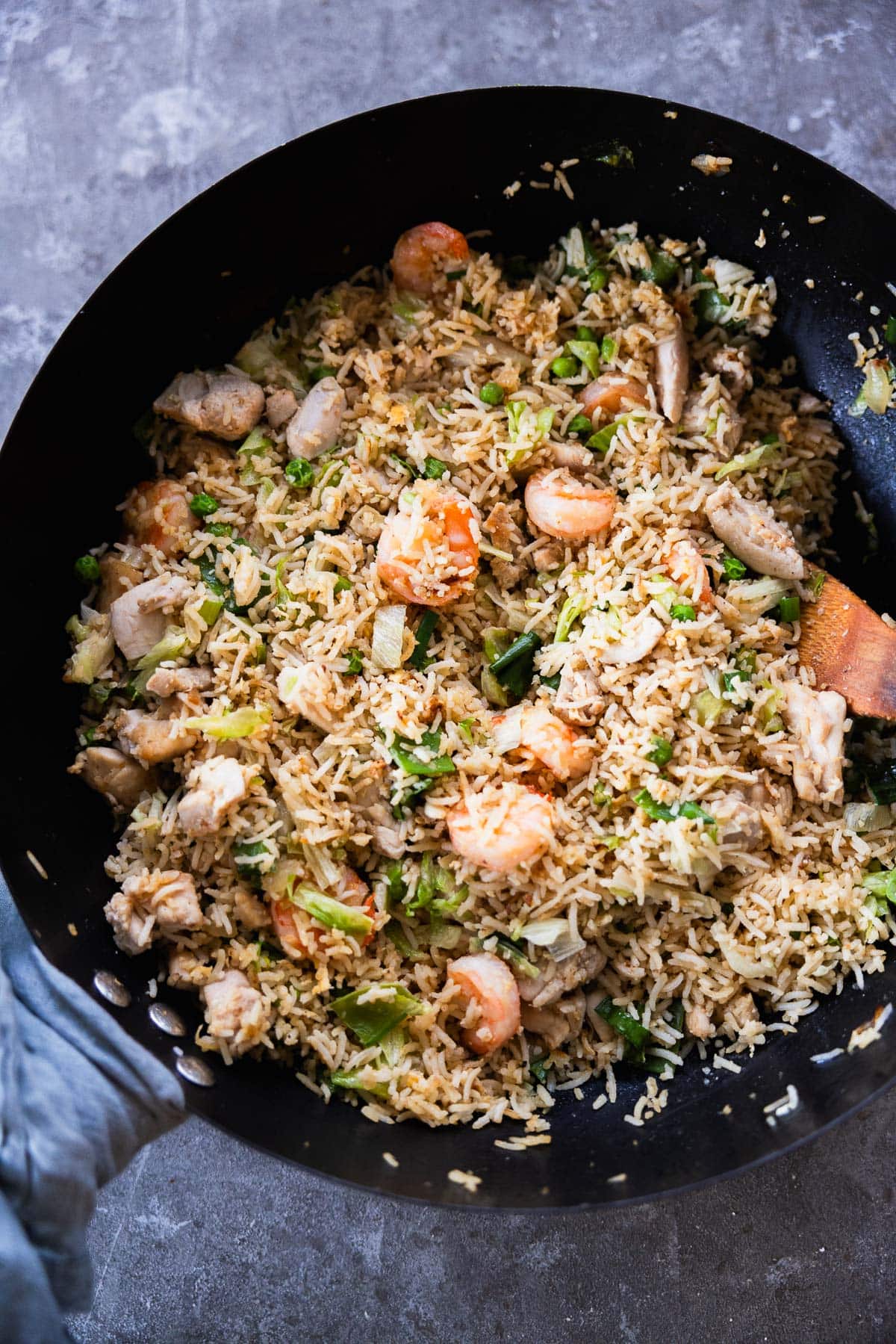 Shrimp And Chicken Fried Rice in a wok with a tea towel around the handle.