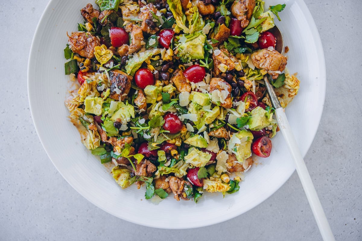 Mexican Chicken Salad served in a white bowl with a sprinkling of parmesan cheese. 