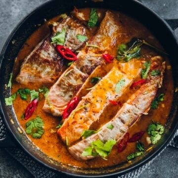 Crispy Salmon in Coconut Lime Sauce in a black pan.