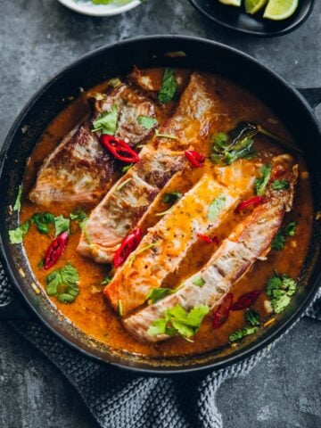 Crispy Salmon in Coconut Lime Sauce in a black pan.