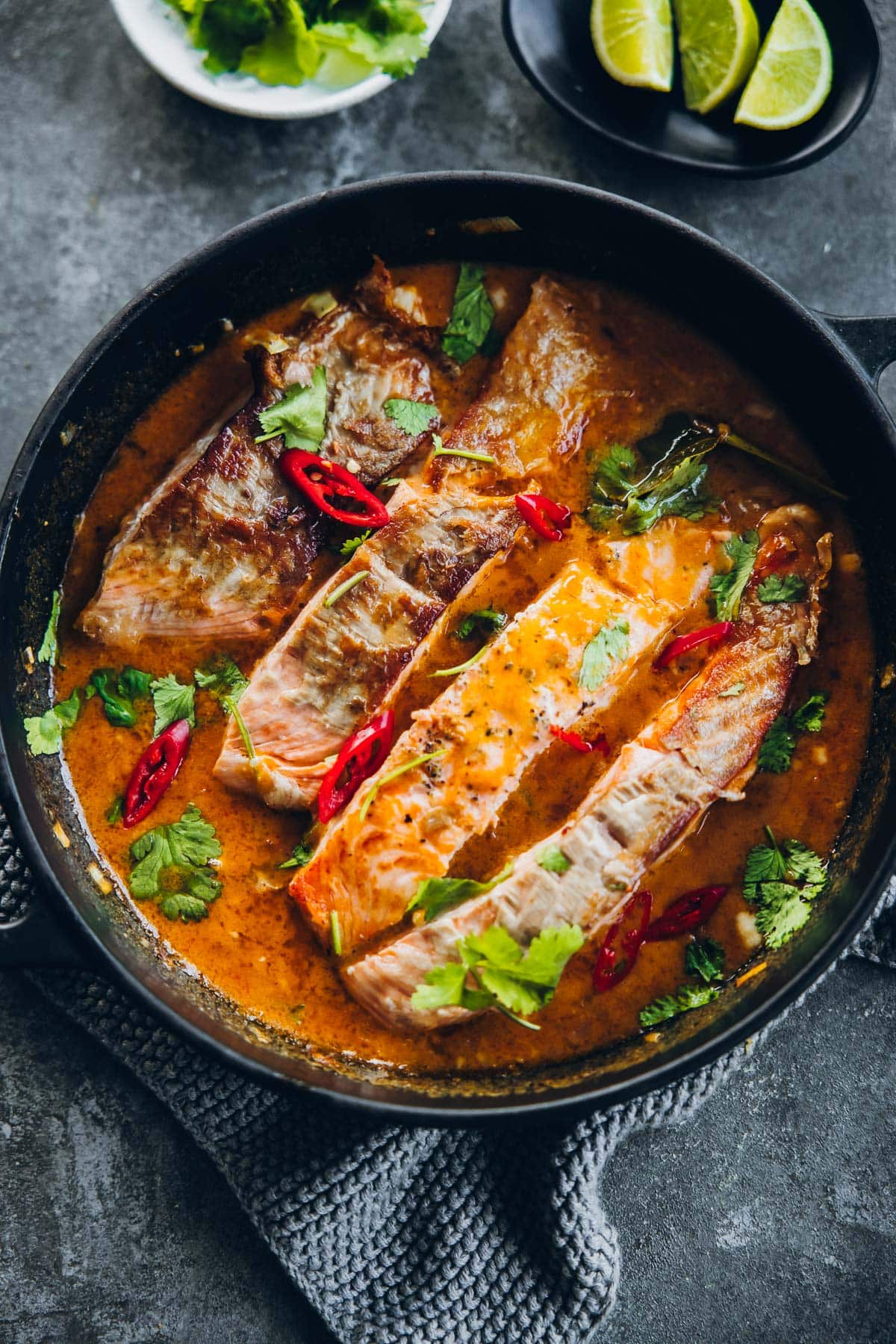 Crispy Salmon in Coconut Lime Sauce in a black pan.