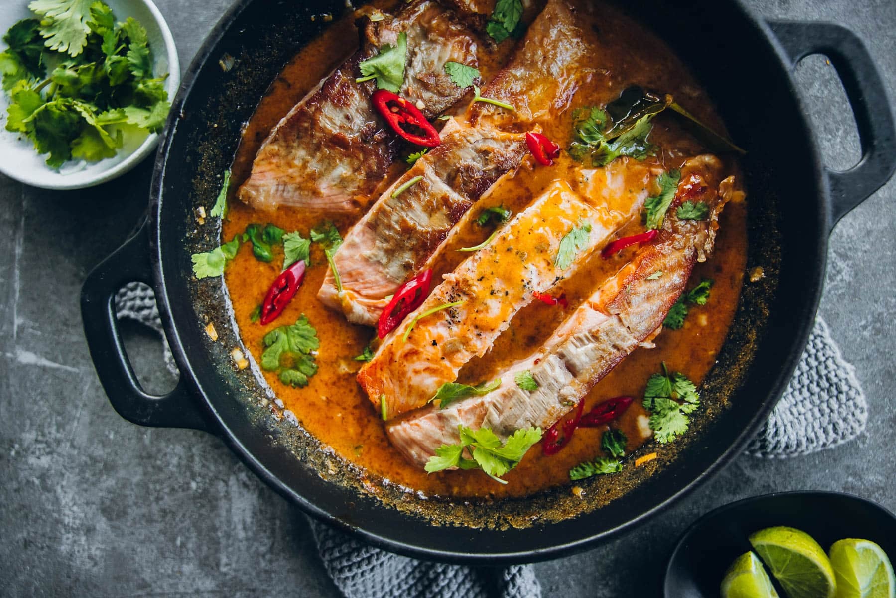 Garnish Crispy Salmon in Coconut Lime Sauce with red chilli and coriander.